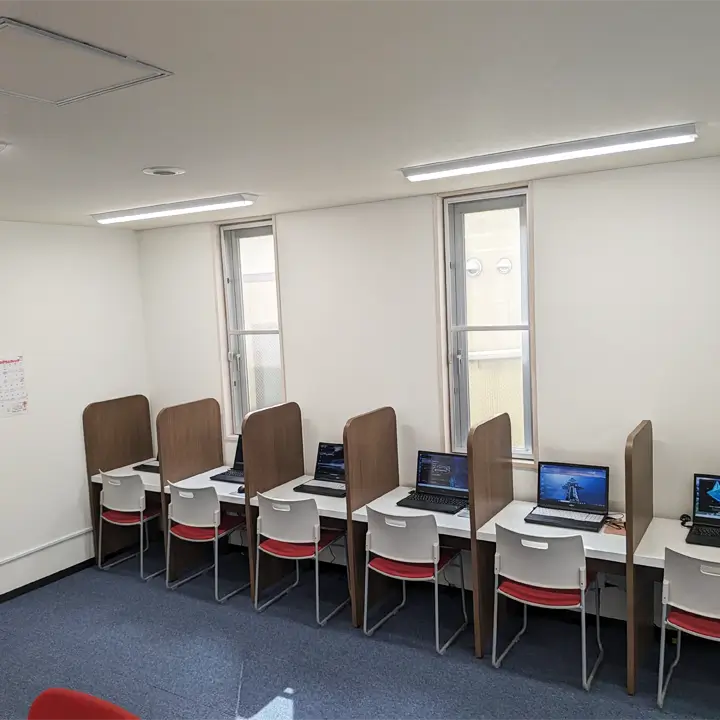 個別に間仕切りが付いていてパソコンが置かれた机がいくつも設置されている訓練スペースの様子